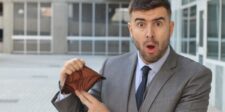 Man in a suit looking surprised while showing an empty wallet, symbolizing challenges of starting a business in Canada with no money.