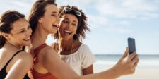 The best social media management tools for your business Three women taking a selfie together at the beach.