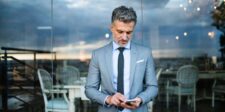 How to use business text messaging without annoying customers Business professional sending a text message on a smartphone, illustrating customer communication through business SMS.