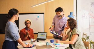 Small business team discussing social media content and policy around a meeting table.