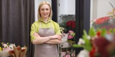 Florist standing in a flower shop surrounded by fresh bouquets, representing a small business owner using SEO to attract more customers.
