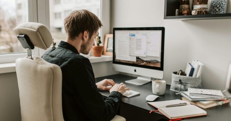 Person working at a desktop computer in a home office, representing SEO work and website optimization