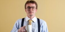 Rank higher on Google with 7 SEO truths that still matter Business professional wearing glasses and holding a coffee mug against a plain background.