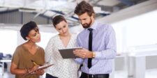 Delegation in business: how to lead without doing everything yourself Manager reviewing work with two team members, illustrating delegation and shared responsibility in business.