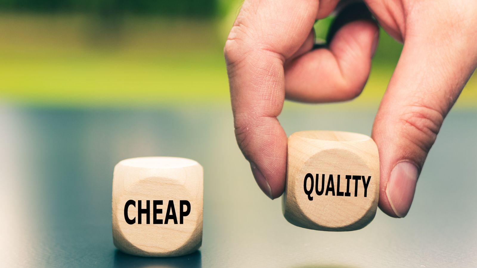 Two dices. One reads 'cheap' and the other 'quality'. The latter is raised higher to illustrate to cheap customers that quality is more important.