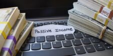 Stacks of money on a laptop keyboard with a label that reads "Passive Income," symbolizing the concept of generating income through online avenues such as Amazon. This image is perfect for illustrating the ultimate guide to making passive income with Amazon.