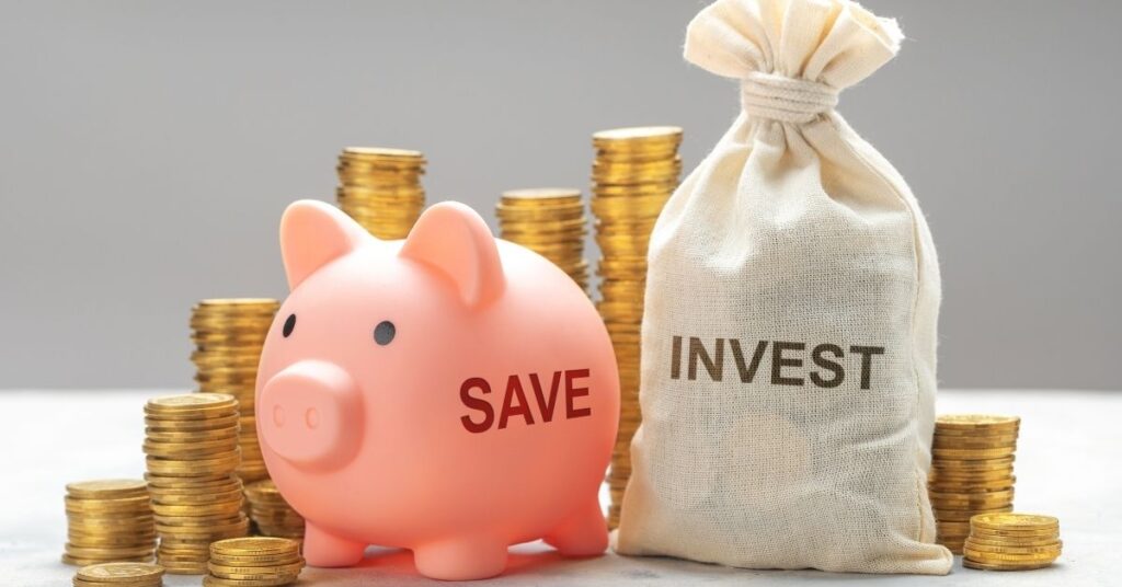 Image featuring a piggy bank labeled 'SAVE' next to a sack labeled 'INVEST', with stacks of coins surrounding them.