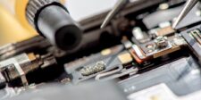 Detailed view of soldering and precision tool work during data recovery from mobile devices, emphasizing the intricate procedures involved in accessing and repairing internal components.