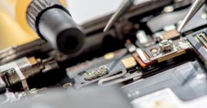 Detailed view of soldering and precision tool work during data recovery from mobile devices, emphasizing the intricate procedures involved in accessing and repairing internal components.