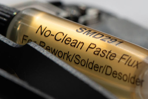 Close-up of SMD291 No-Clean Paste Flux syringe used in data recovery from mobile devices, highlighting its role in precision soldering and desoldering tasks.