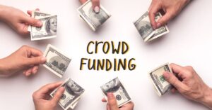 Hands holding dollar bills around the word 'Crowd Funding,' representing a collaborative effort to raise money through a crowdfunding pitch.