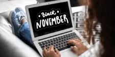Black November Holiday: Big Perks for Shoppers and Businesses A person using a laptop displaying a Black November sale banner, featuring bold white text that reads 'Black November' on a black background with decorative elements, promoting holiday shopping deals.