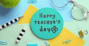 Colorful stationery surrounding a circular card with 'Happy Teacher's Day' written on it, celebrating World Teachers Day.