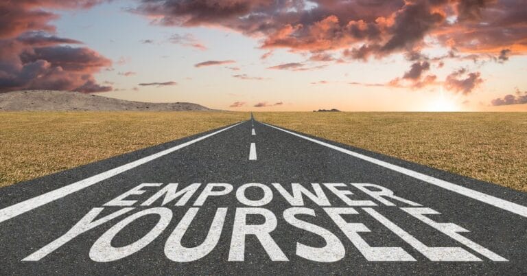 Long road at sunrise with 'Empower Yourself' written on the asphalt, symbolizing personal growth and self-empowerment inspired by Richard Branson's philosophy.