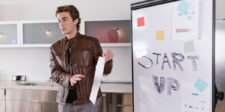 Young entrepreneur presenting a startup idea on a whiteboard with the word 'START UP' written in bold letters, showcasing innovation and the future of entrepreneurship.