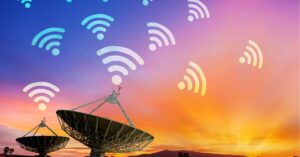 Satellite dishes pointing towards a colorful sunset sky with Wi-Fi symbols above, representing connectivity. This image illustrates methods for obtaining free data and internet access through various sources and strategies.