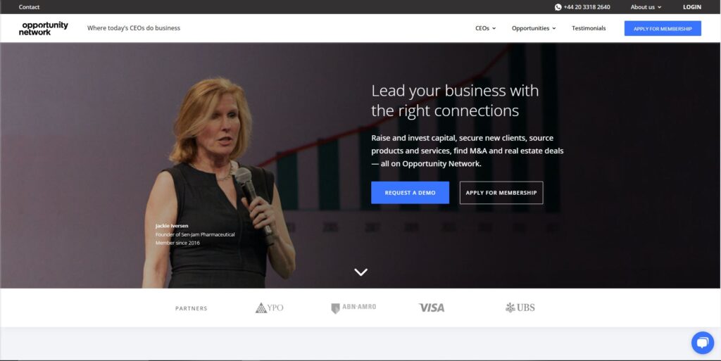 Screenshot of the Opportunity Network homepage, displaying a banner image of a businesswoman speaking at an event. The platform promotes itself as a space 'Where today's CEOs do business,' offering services like raising capital, sourcing products, and finding M&A deals. The page includes options to request a demo or apply for membership