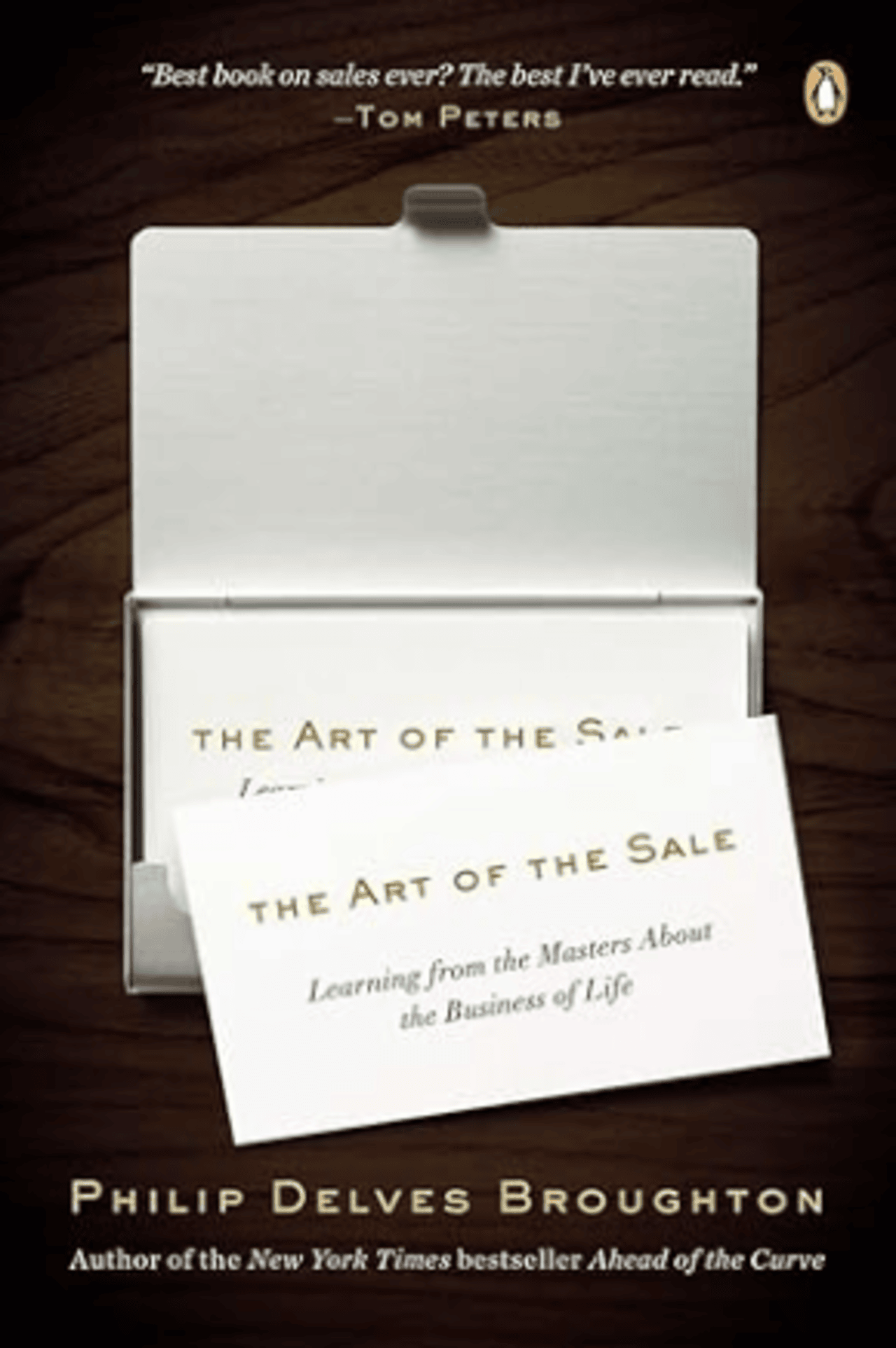 Cover of 'The Art of the Sale' by Philip Delves Broughton, featuring an open business card holder with the title displayed on a card, set against a dark wood background.