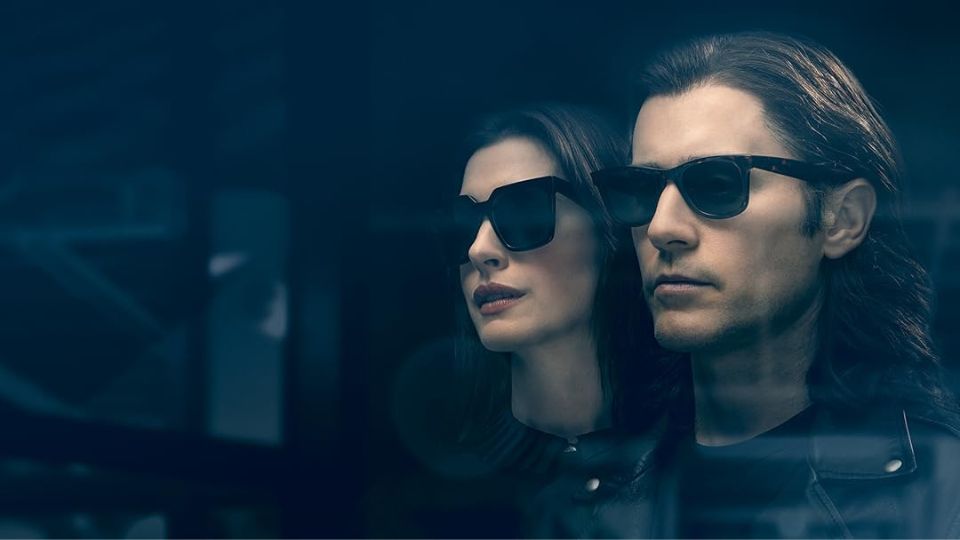 Promotional image for WeCrashed showing the two main characters wearing dark sunglasses against a dark blue background.