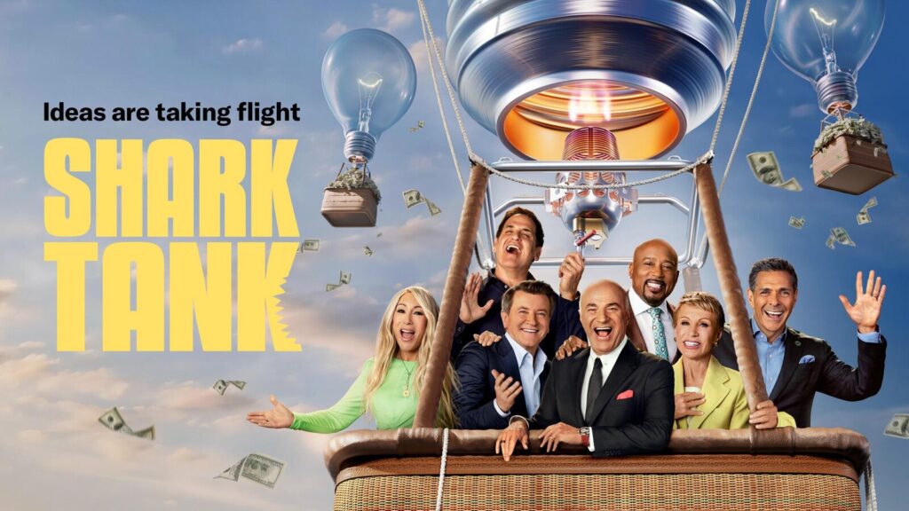 Promotional image for "Shark Tank," showcasing the panel of business investors seated in a hot air balloon shaped like a light bulb, surrounded by floating dollar bills and a vibrant blue sky. The phrase "Ideas are taking flight" is prominently displayed.