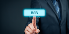 Business person in a suit pointing at a glowing "B2B" button labeled "B2B Digital Marketing."