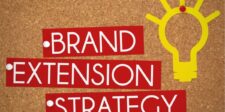 "Brand Extension Strategy" text on a corkboard with a yellow lightbulb graphic.