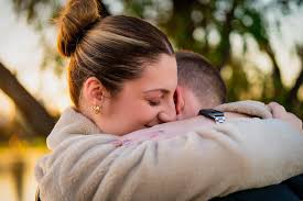 Two people embracing warmly outdoors.