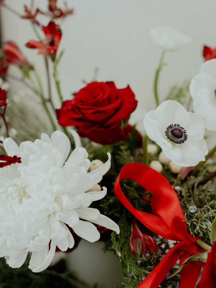 Bouquet with red roses, white flowers, and a red ribbon.