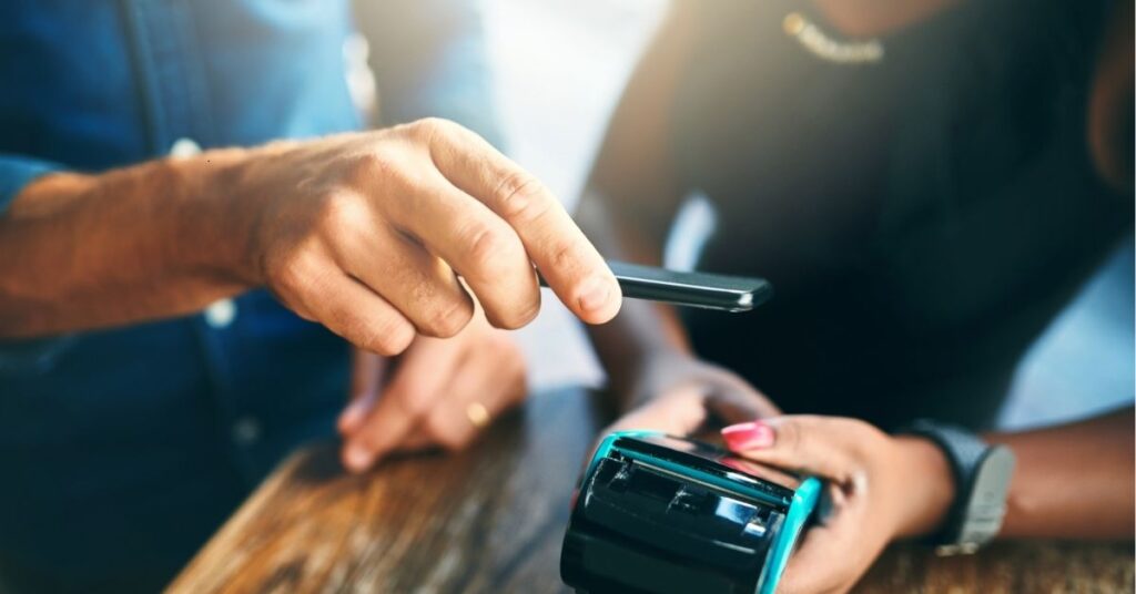 Person making a contactless payment with a smartphone.