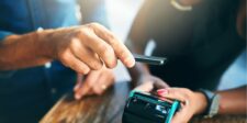 Person making a contactless payment with a smartphone.