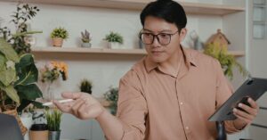 Person holding a tablet and stylus while working at a desk in a home office