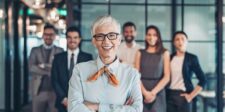 Confident businesswoman standing in front of her team in an office.