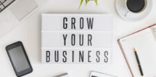 Desk setup with a lightbox reading "Grow Your Business." | work on your business