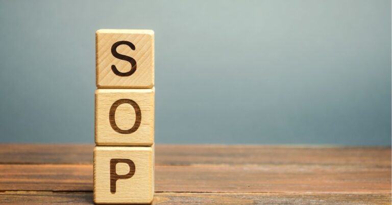 "Wooden blocks stacked vertically spelling 'SOP,' representing Standard Operating Procedures on a wooden surface with a neutral background."