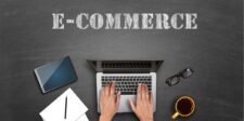 Best Books on Ecommerce for Branding & Growth Strategies Hands typing on a laptop with "E-COMMERCE" text above. Tablet, notepad, glasses, and coffee nearby.
