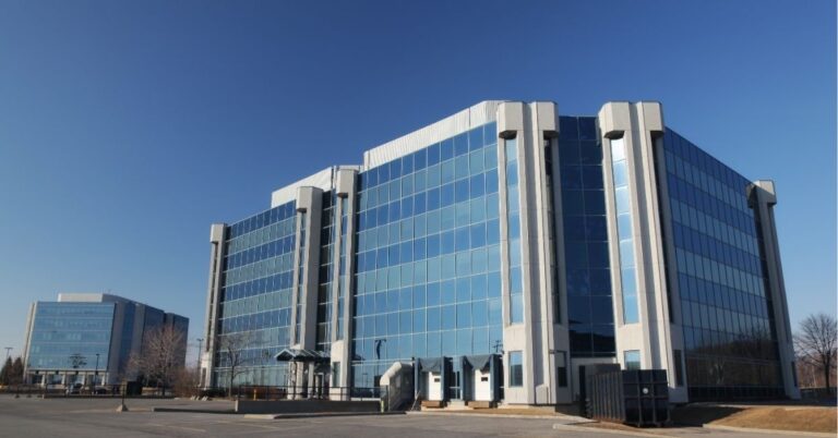 Modern glass office buildings under a clear blue sky. Text: "Innovation Hub! Discover New Opportunities in Business Spaces."