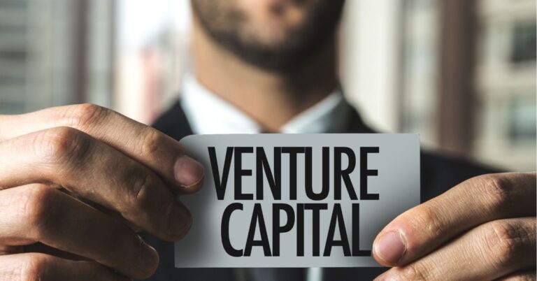 Person holding a sign that says "Venture Capital."