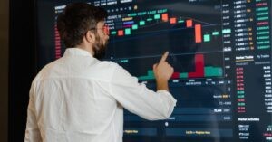 Man analyzing stock market data on a screen. Text: "Mastering Market Trends for Smarter Investments!"