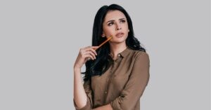 Thoughtful woman holding a pencil to her chin.