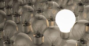 A single lit lightbulb among unlit ones.