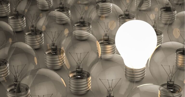 A single lit lightbulb among unlit ones.