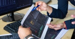 Professionals analyzing charts and graphs in a meeting.