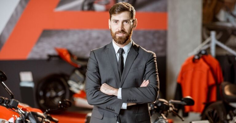 Confident professional in a suit standing in a motorcycle showroom.