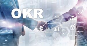 Handshake with overlay text "OKR" and icons for objective, key result, and target.