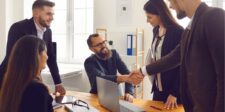 Team meeting with handshake across a table.