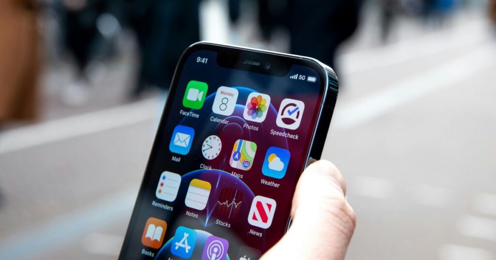 Person holding a smartphone displaying 5G signal strength and mobile apps, illustrating eSIM connectivity in real-world use.