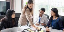 Breakthrough in Business: 10 Proven Strategies That Work Team collaborating around a table with sticky notes and documents.