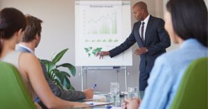 Presenter explaining charts and graphs in a business meeting.