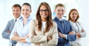 Smiling business team standing confidently with arms crossed.