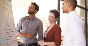 Team discussing ideas at a flip chart, smiling and engaged.